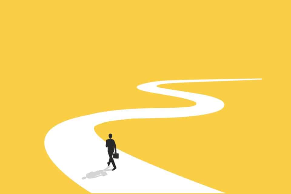 Figure of a person walking on a path leading off into the distance against a yellow background.