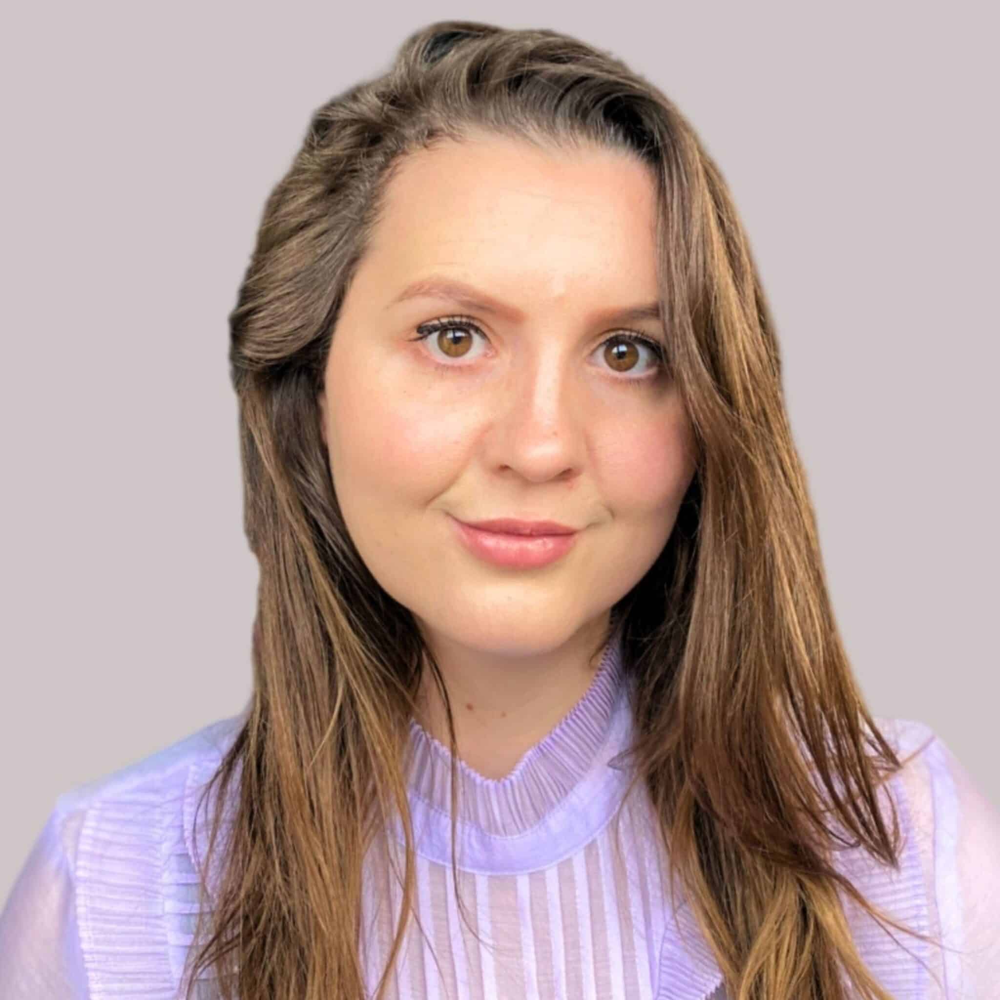 Photo of young woman with long brown head wearing a lilac top