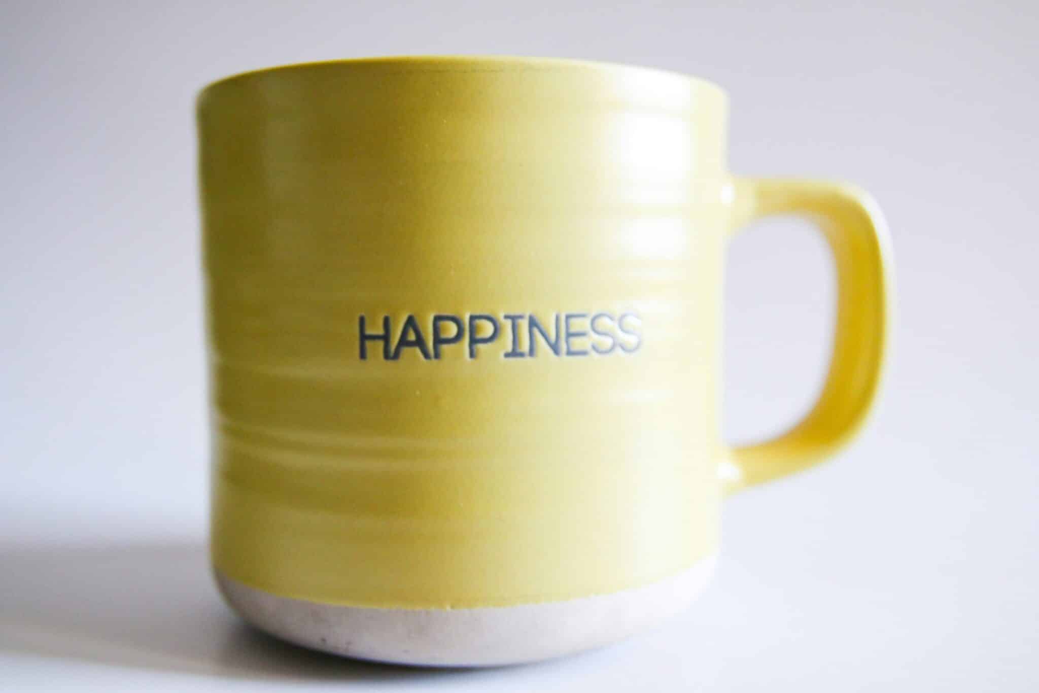Yellow mug with happiness written on it