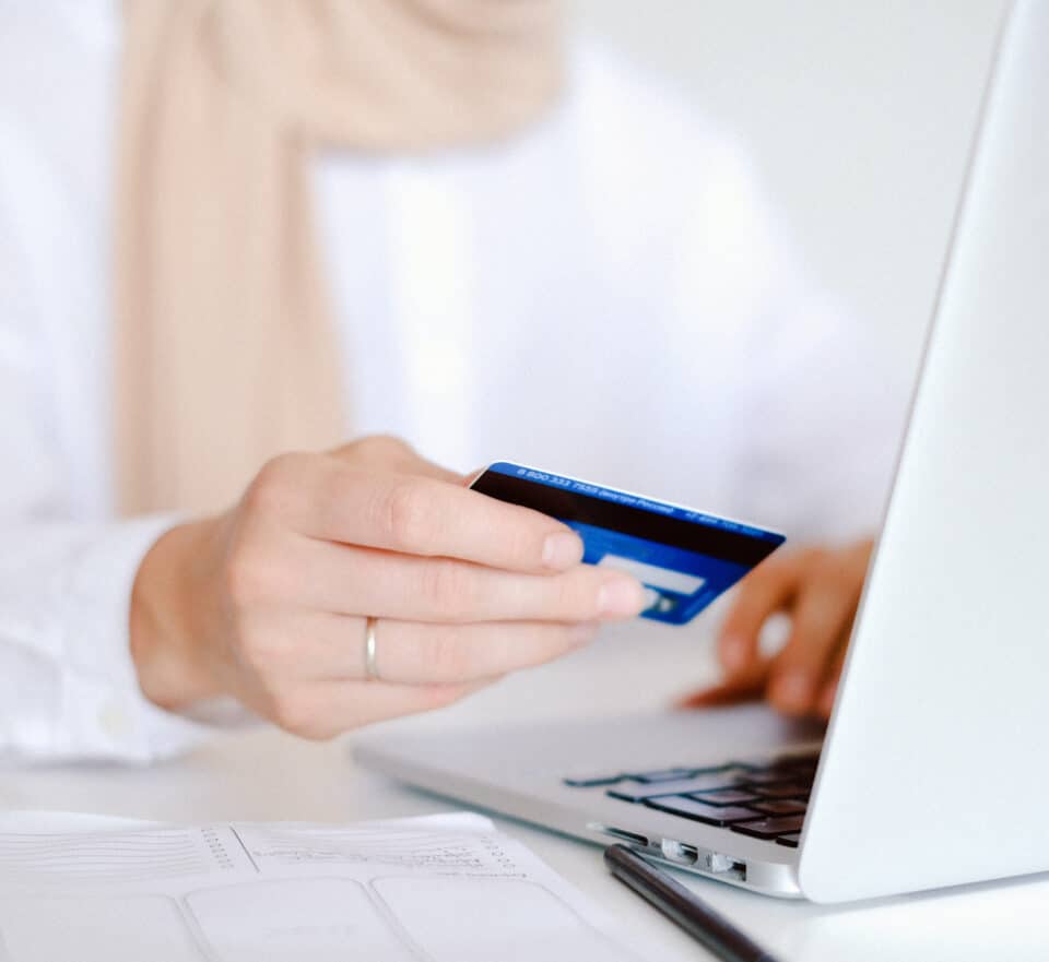 Woman sat at laptop using a credit card