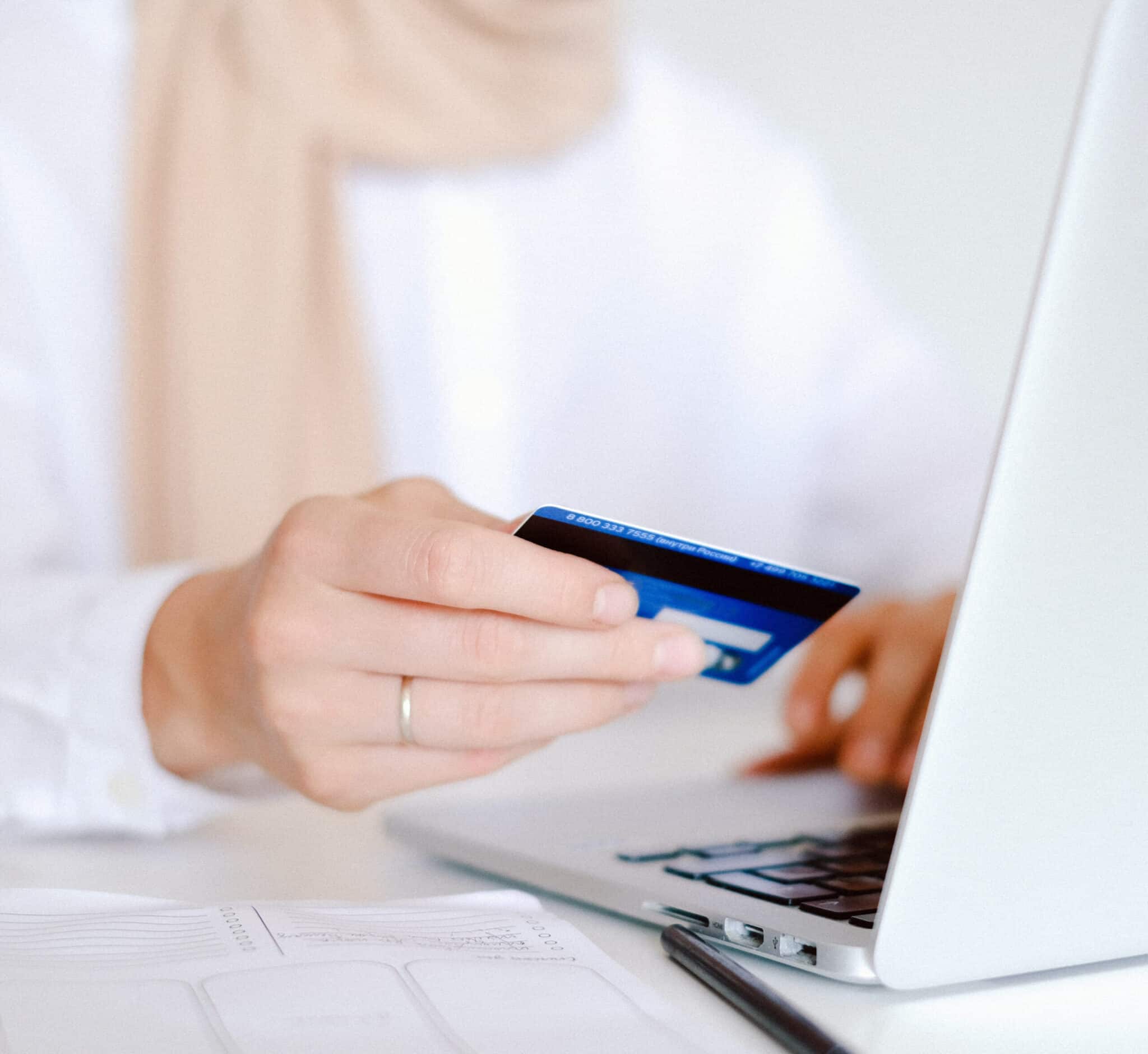 Woman sat at laptop using a credit card