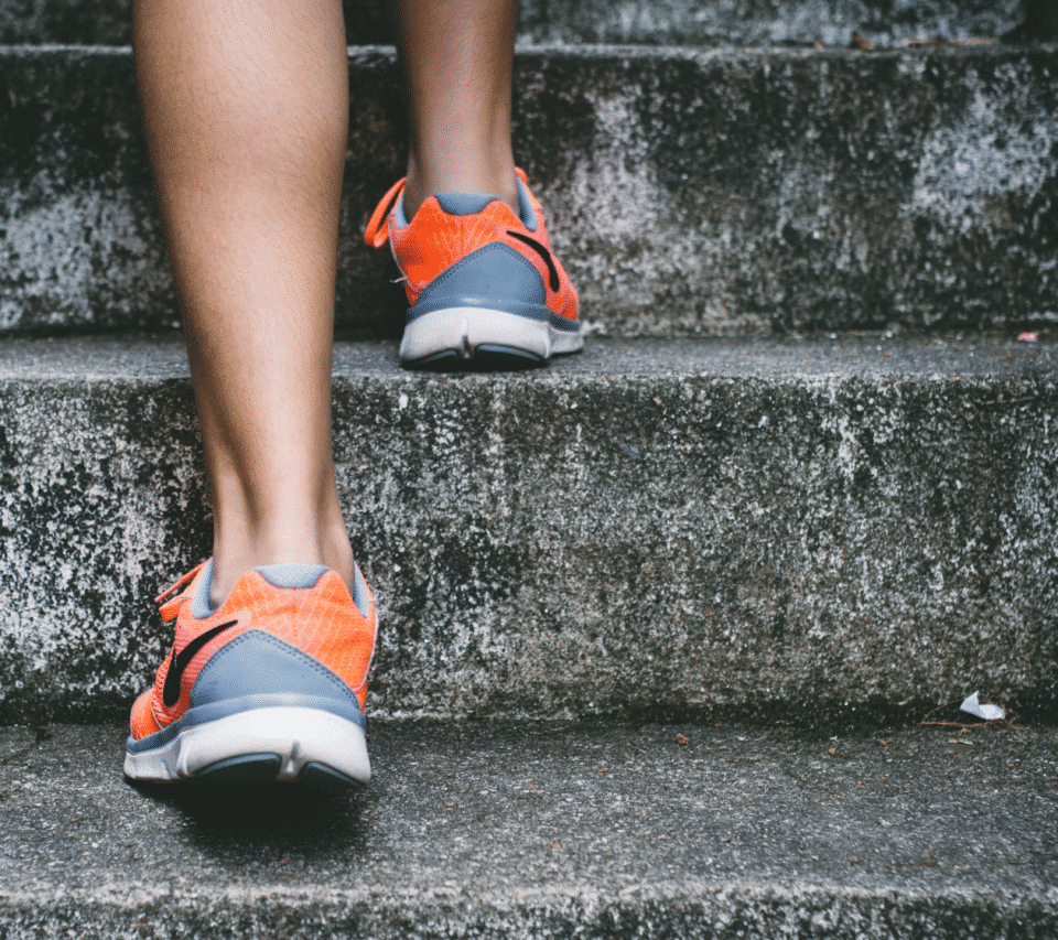 Person in orange and grey trainers walking up some steps