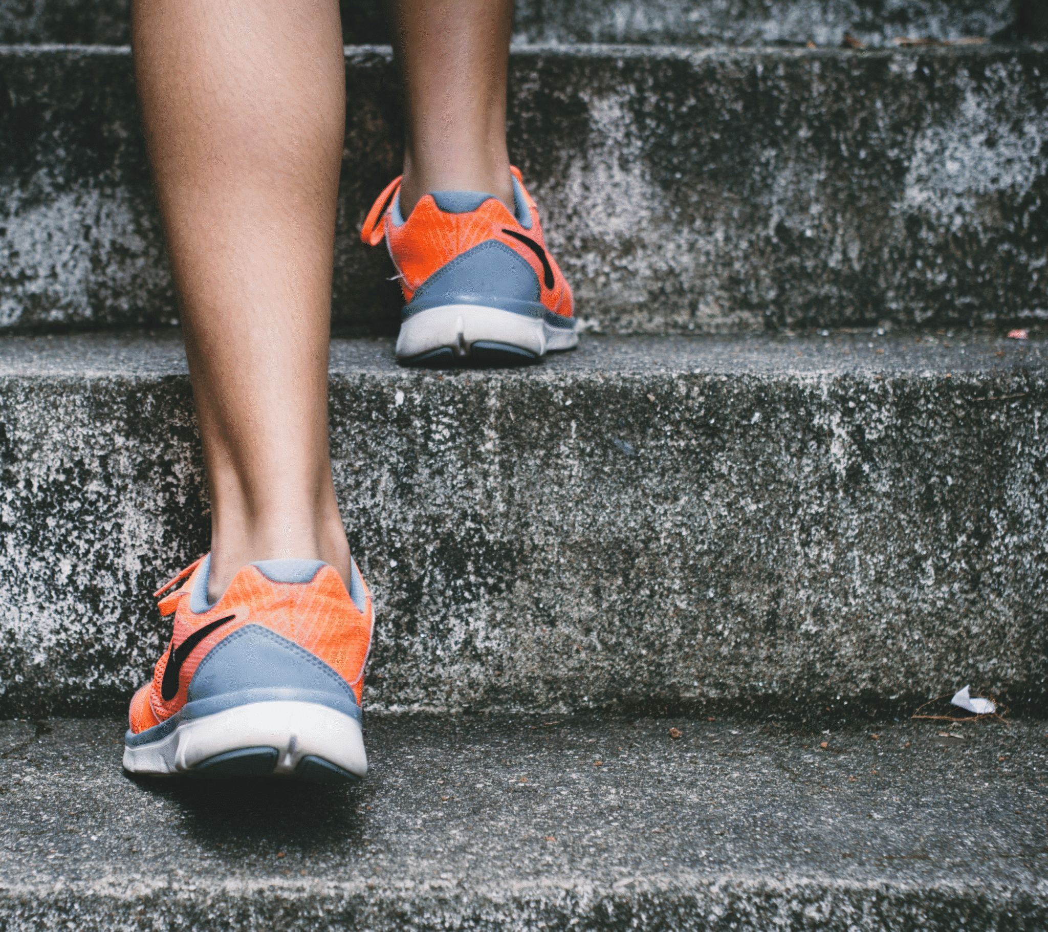 Person in orange and grey trainers walking up some steps