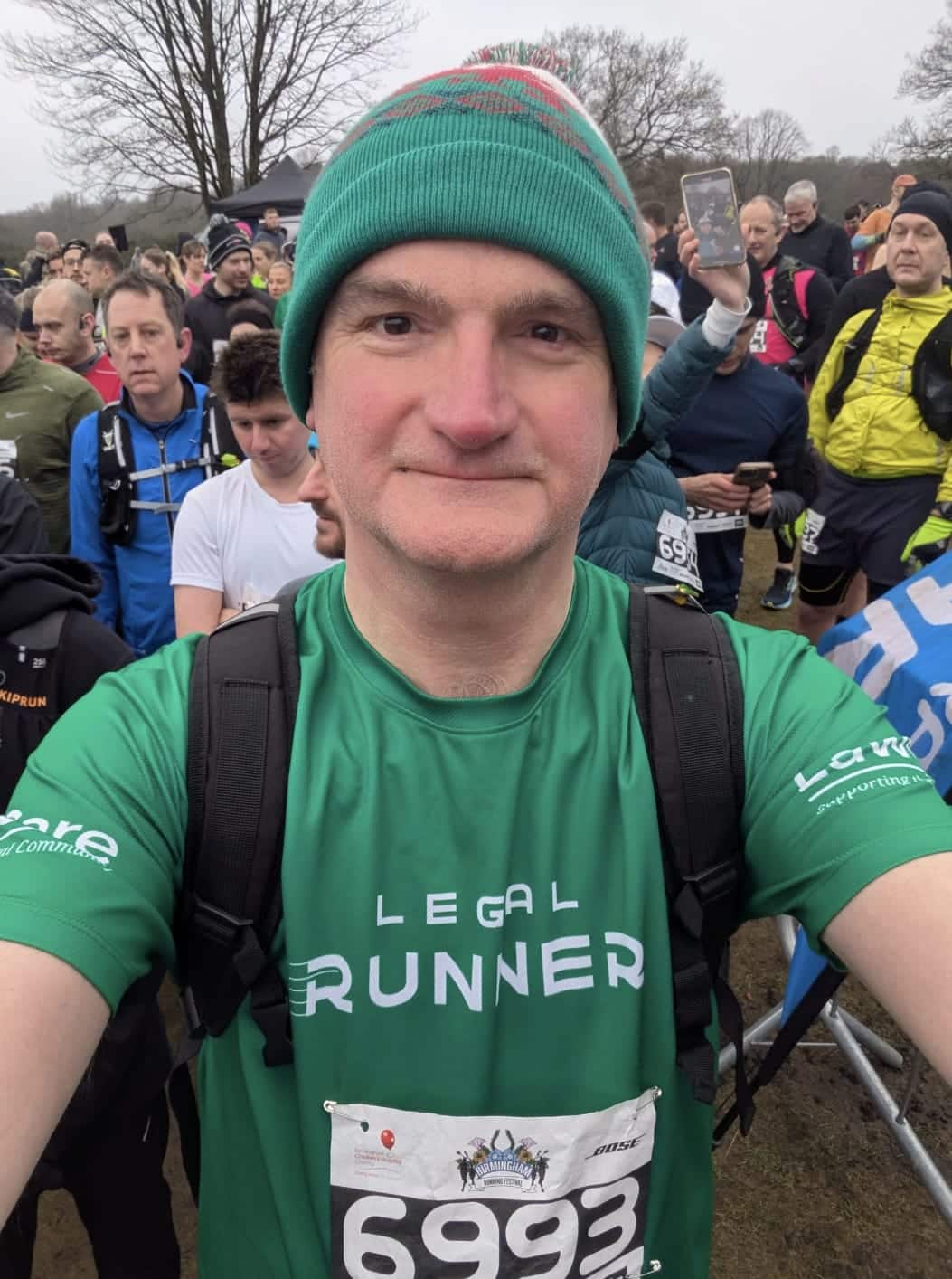 Mark Evans at the start of a run, wearing a green ‘Legal Runner’ top and a green hat, with other runners behind him.