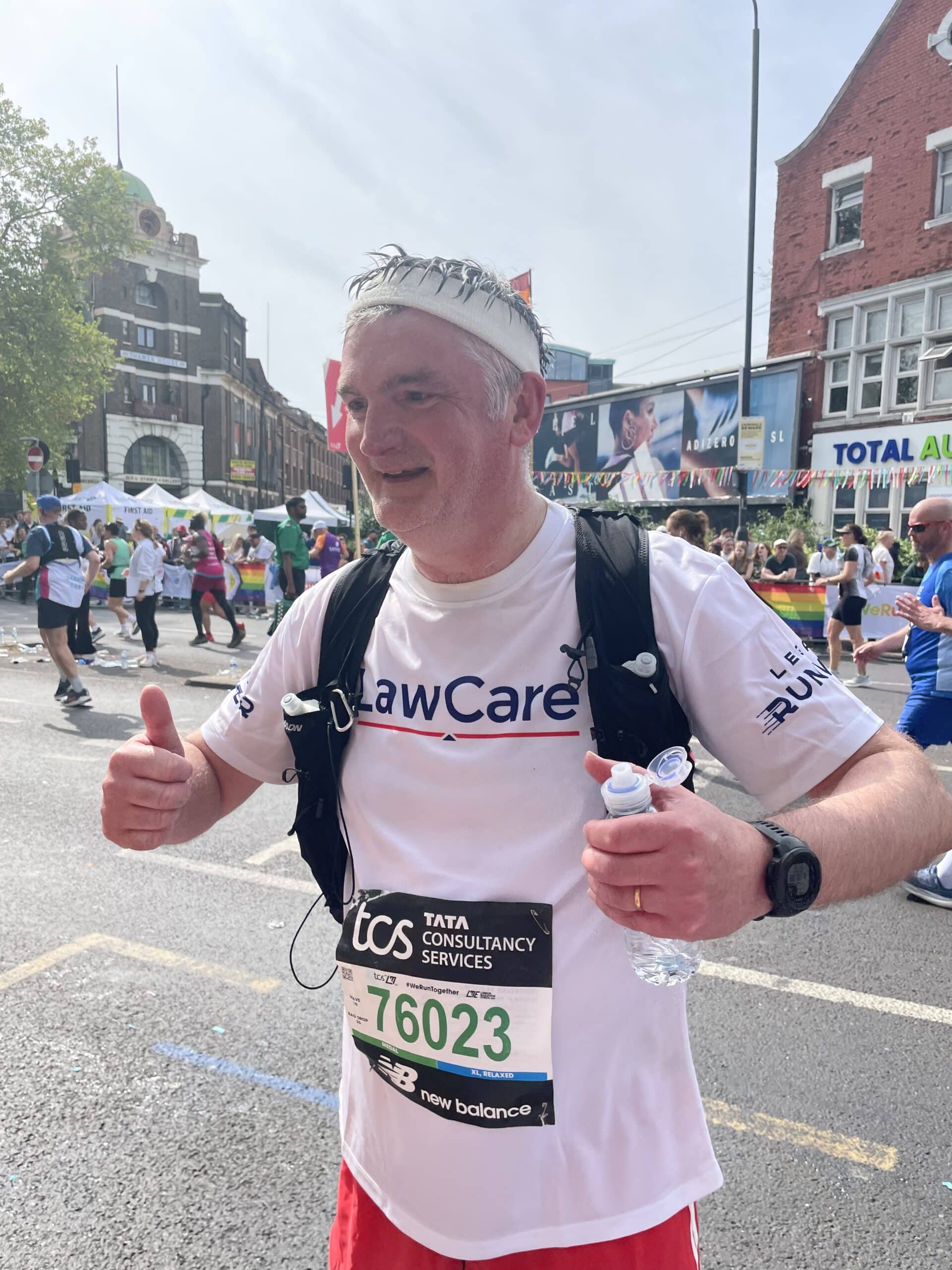 Mark mid race (mile 21) looking happy, hot and giving a thumbs up and wearing a LawCare t-shirt.