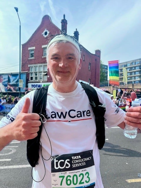 Mark mid race (mile 21) looking happy, hot and giving a thumbs up and wearing a LawCare t-shirt.