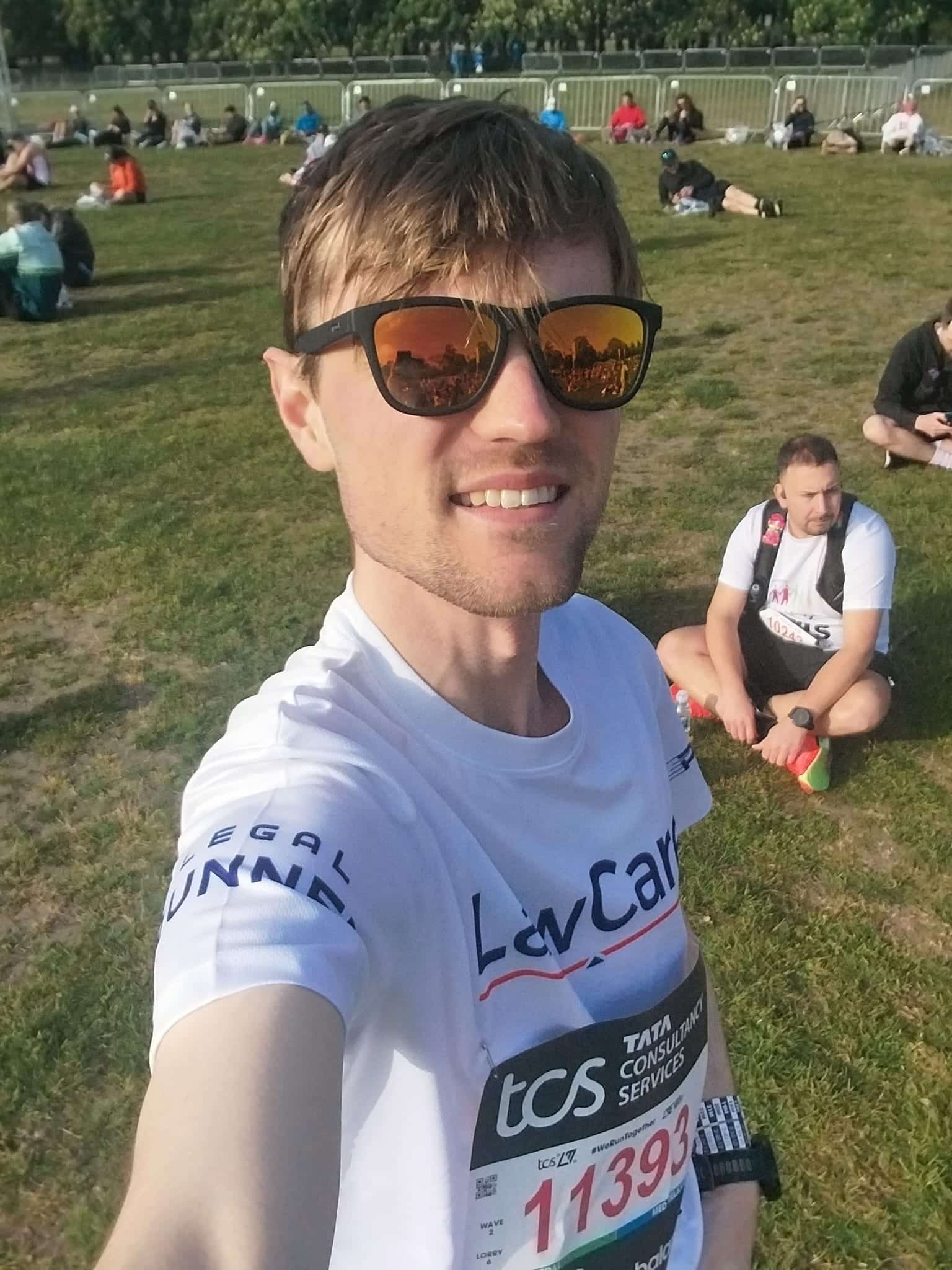 Matt before the race in a park area, on grass, wearing a LawCare t-shirt.