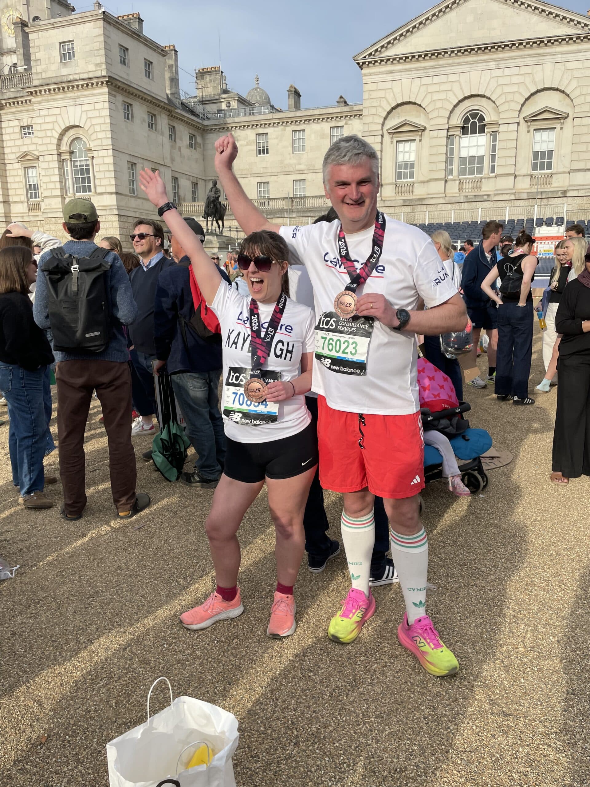 Mark and Kayleigh with their medal after the race. Each wearing a LawCare t-shirt and look very happy.