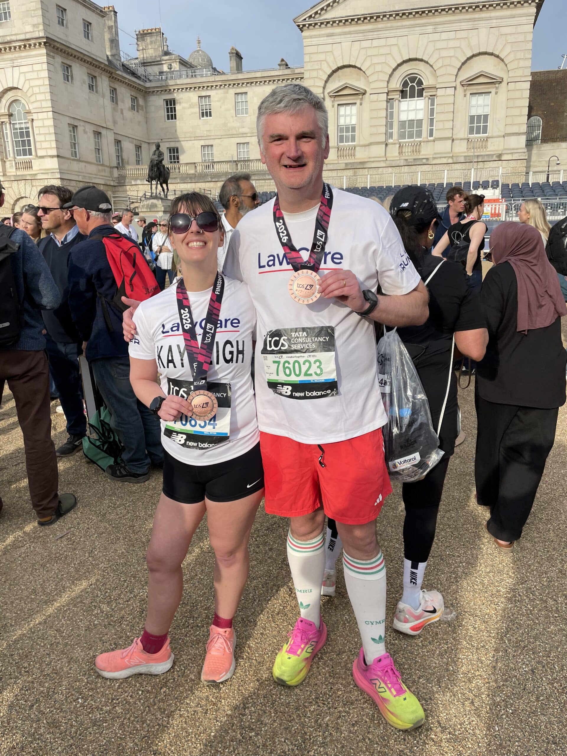 Mark and Kayleigh with their medal after the race. Each wearing a LawCare t-shirt and look very happy.