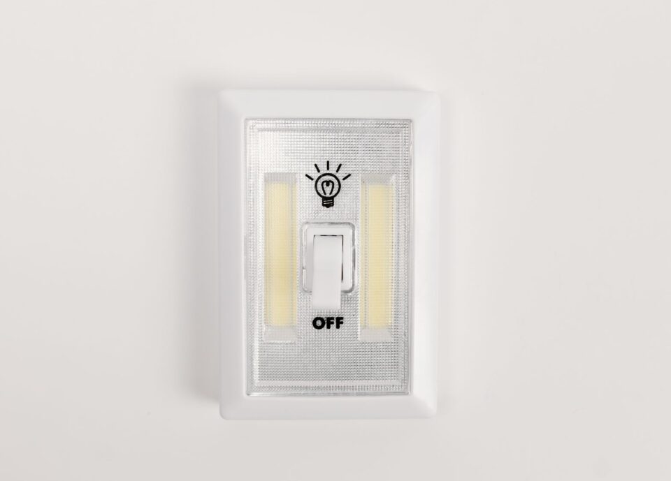 Light switch on a white wall with an off setting and a light bulb where the on would be.
